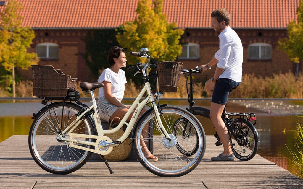Dame und Herr mit Fischer E-Bikes am Steg